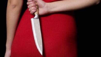 Frau mit Messer hinter dem Rücken