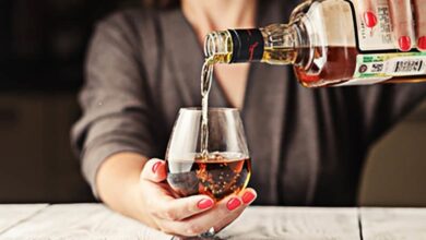 Frau schenkt sich Alkohol ein